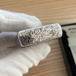 Angled lid-top view showing dark recessed scrollwork and polished edges