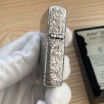 Straight hinge-side view of the five-sided silver-tone arabesque Zippo