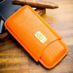 Orange woven leather wallet with a gold Lubinski brand plaque on a wooden table surface.