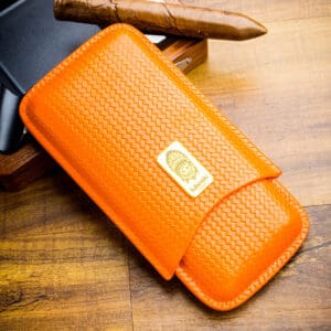 Orange woven leather wallet with a gold Lubinski brand plaque on a wooden table surface.