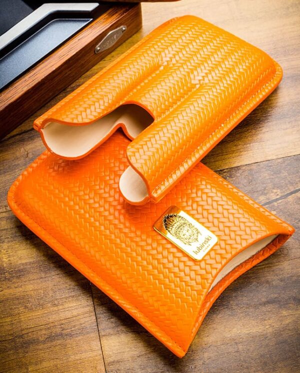 Orange woven leather wallet and matching sleeve on a wooden surface.