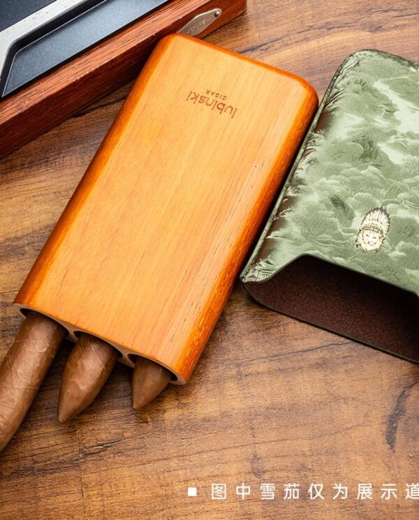 YJA-50030-03 Wooden cigar holder with three cigars protruding, beside a green textured wallet on a wooden desk; disclaimer in Chinese notes props for display.