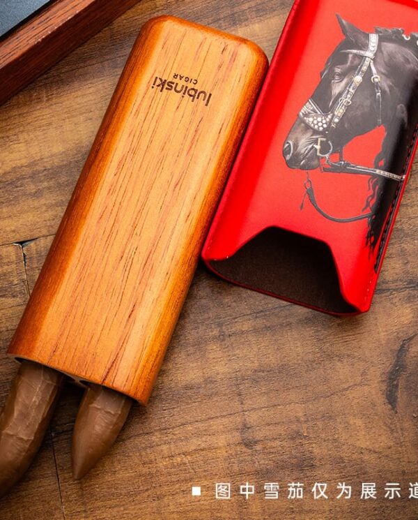 YJA-50031-03 Wooden cigar tube with two cigars emerging, placed beside a red case featuring a black horse illustration on a wooden surface.