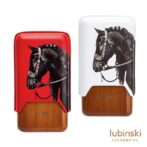 Two Lubinski cigar cases: red and white tops with a black horse head illustration, and a wooden base.