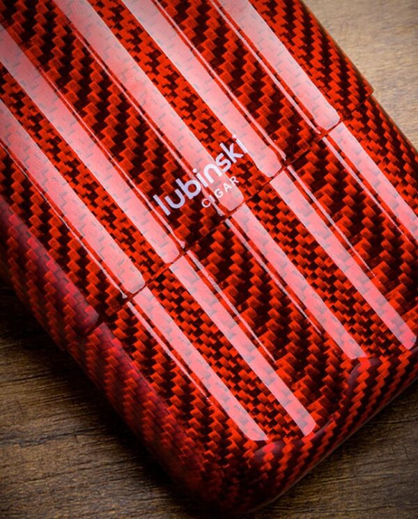 Close-up of a red carbon-fiber patterned phone case with white diagonal stripes on a wooden surface.