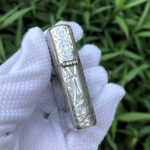 White Tara five-side sterling silver Zippo lighter – hinge-side view with lotus stems and cloud-pattern engraving