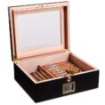 Open wooden cigar humidor with a glass lid, cigars arranged in rows inside and a digital humidity display on the front showing 65%.