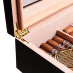 Open wooden cigar humidor showing cigars arranged inside and a gold hinge on the lid