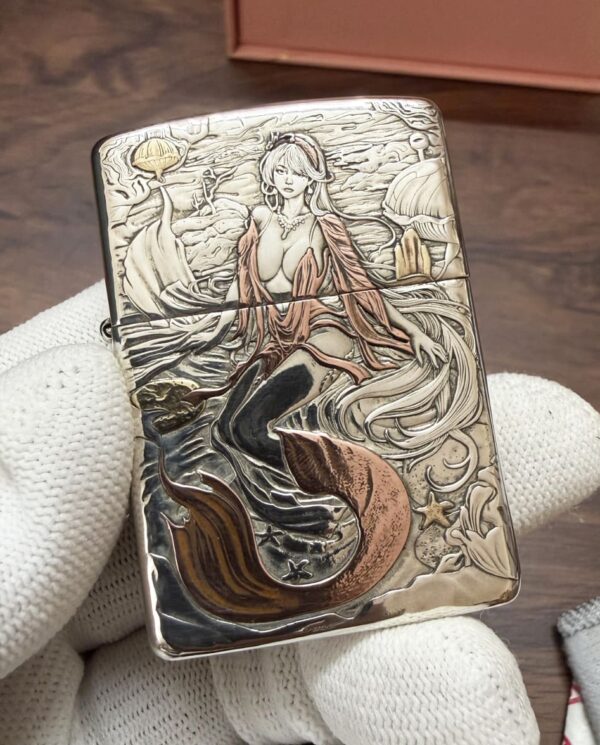 KZ003_09 Decorative metal lighter with a detailed mermaid illustration amid waves and shells in bronze tones.