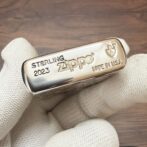 Sterling Zippo lighter engraved with 'STERLING 2023' and 'MADE IN U.S.A.' held by a white-gloved hand.