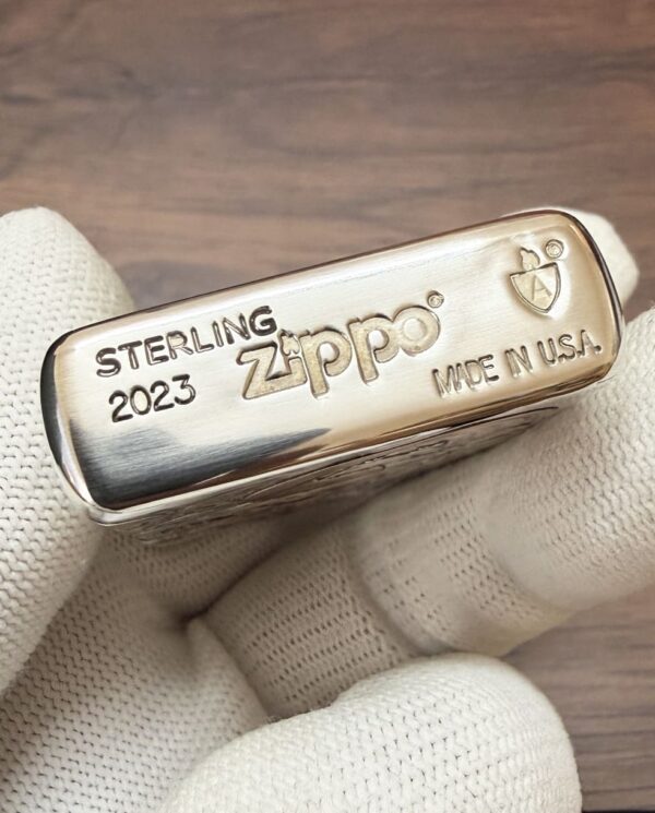 KZ003_10 Sterling Zippo lighter engraved with 'STERLING 2023' and 'MADE IN U.S.A.' held by a white-gloved hand.