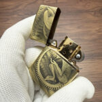 Skeletal engraving detail on the brushed-brass Alien Armor lighter