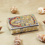 Angled detail of the White Tara Zippo Armor lighter with selective gold accents