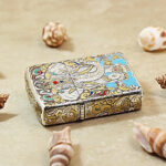 Angled detail of the Indian Elephant Zippo Armor lighter with selective gold accents