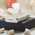 Female Warriors silver-and-gold Zippo Armor lighter displayed with Zippo packaging