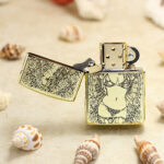 Open brass Zippo Armor lighter showing the female figure and floral engraving