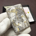 Angled view of the silver and gold Guanyin Zippo Armor design