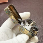 Silver engraving and gold-tone decorative accents contrast on the pharaoh Zippo case