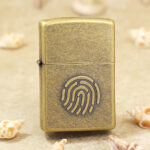 Zippo Classic antique brass-tone lighter with fingerprint emblem front view