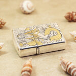 Zippo Armor mermaid engraved lighter lying flat showing continuous artwork
